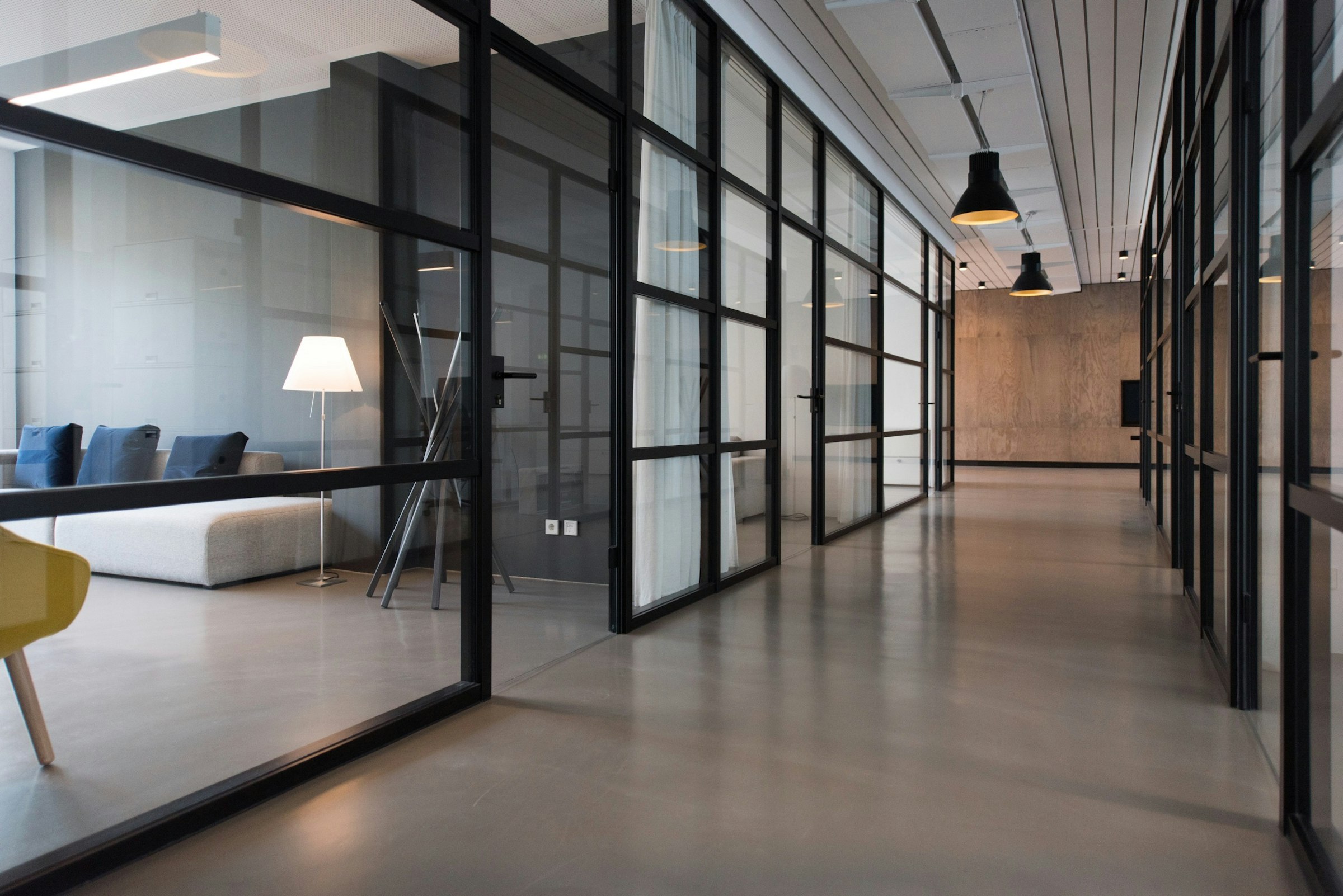 Hochwertig montiertes Büro mit Glaswänden und Premium-Möbeln